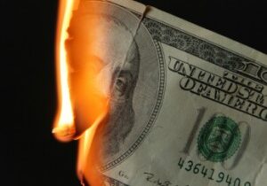 Burning dollars close up over black background